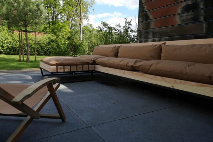 Een stoere Loungebank met hocker en kussens.